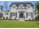 Beautiful two-story house featuring a white brick exterior, black shutters, and a well-manicured lawn at 7723 Roberts Rd, Apex, NC 27523