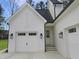The exterior of this home features a white garage with black hardware and matching outdoor lighting at 7723 Roberts Rd, Apex, NC 27523