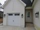 Attached garage with carriage-style doors and traditional outdoor lighting at 7723 Roberts Rd, Apex, NC 27523