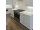 Kitchen featuring stainless steel oven, white cabinets with gold hardware, and marble countertops at 7723 Roberts Rd, Apex, NC 27523