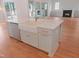 A kitchen island features a farmhouse sink, white cabinets, and gold fixtures at 7723 Roberts Rd, Apex, NC 27523