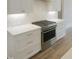 Kitchen featuring stainless steel oven, white cabinets with gold hardware, and marble countertops at 7723 Roberts Rd, Apex, NC 27523