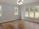 Bright and airy living room with hardwood floors, multiple windows and modern light fixture at 7723 Roberts Rd, Apex, NC 27523