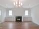 Bright living room featuring a fireplace with mantle, custom cabinetry, and elegant light fixtures at 7723 Roberts Rd, Apex, NC 27523
