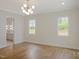 Living room with hardwood floors, large windows and modern light fixture at 7723 Roberts Rd, Apex, NC 27523