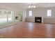 Large living room with fireplace, built-in shelving, hardwood flooring and sliding glass door to outdoor area at 7723 Roberts Rd, Apex, NC 27523