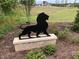 Detailed black lion statue on a brick pedestal amidst greenery, adding a touch of elegance to the landscape at 7723 Roberts Rd, Apex, NC 27523