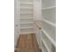 Custom storage area featuring cabinets, drawers, and shelving with hardwood floors at 7723 Roberts Rd, Apex, NC 27523