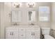 Bright bathroom featuring a double vanity with marble countertop, white cabinets, and stylish lighting at 912 Obsidian Way, Durham, NC 27703