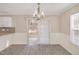 Dining room with a chandelier, gray flooring, white wainscoting, and sliding glass door access to backyard at 912 Obsidian Way, Durham, NC 27703