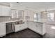 A stylish kitchen featuring a stainless steel sink, white cabinets, and black tiled floors, enhanced by natural light at 912 Obsidian Way, Durham, NC 27703