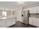 Open kitchen with a breakfast bar island, stainless steel fridge, white cabinets and black tile floor at 912 Obsidian Way, Durham, NC 27703