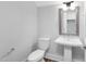 Bright powder room with a pedestal sink, wood-look flooring, and a modern framed mirror at 913 Myers Point Dr, Morrisville, NC 27560