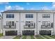 New construction townhomes with white siding, black trim, balconies and dark garage doors at 913 Myers Point Dr, Morrisville, NC 27560