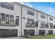 Townhome exteriors featuring white siding, dark trim, balconies, and dark garage doors at 913 Myers Point Dr, Morrisville, NC 27560