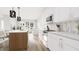 Bright modern kitchen featuring white cabinets, stainless steel appliances, island with seating, and open to the living area at 913 Myers Point Dr, Morrisville, NC 27560