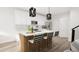 Modern kitchen featuring white cabinets, a wood-tone island with seating, stainless steel appliances, and pendant lighting at 913 Myers Point Dr, Morrisville, NC 27560