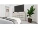 Stylish main bedroom showcasing a modern dresser with gold accents, large TV, and a serene, relaxing atmosphere at 913 Myers Point Dr, Morrisville, NC 27560