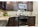 Kitchen featuring stainless steel appliances, granite countertops and dark cabinets at 103 Bella Sq Sq, Smithfield, NC 27577