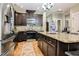 Kitchen featuring stainless steel appliances, dark cabinets, an island with granite countertops, and light-colored flooring at 103 Bella Sq Sq, Smithfield, NC 27577