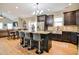 Bright, open-concept kitchen with granite island and seating, stainless steel refrigerator, and seamless flow to the dining area at 103 Bella Sq Sq, Smithfield, NC 27577