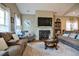 Bright living room with a fireplace, hardwood floors, and a large decorative clock at 103 Bella Sq Sq, Smithfield, NC 27577