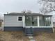 Back exterior featuring light gray siding, access to a sunroom, and a modest backyard at 104 N Garden Ave, Siler City, NC 27344