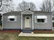Charming one-story home with light gray siding, awning-covered windows and a simple, inviting front entrance at 104 N Garden Ave, Siler City, NC 27344