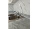 Close-up of a stainless steel kitchen sink with gray countertops and white, marbled backsplash at 104 N Garden Ave, Siler City, NC 27344