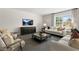 Bright living room featuring plush seating, modern decor, and a large window with natural light at 124 Ethel Ln, Angier, NC 27501