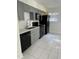 Well-lit kitchen featuring updated gray cabinets, a black appliance package and tile flooring at 130 S Estes Dr # J1, Chapel Hill, NC 27514