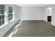 An empty bedroom with ample natural light from a large window and view into the bathroom at 1424 Elk Falls Dr, Wendell, NC 27591