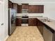 A spacious kitchen with stainless steel appliances and dark wood cabinets. The kitchen is in the corner at 1424 Elk Falls Dr, Wendell, NC 27591