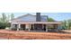 Community Building exterior with stone, siding, a large porch with fireplace, and ample parking nearby at 148 Kobus Ct, Garner, NC 27529