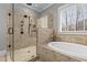 Bathroom featuring a large glass enclosed shower, soaking tub and natural light at 198 Gentry Dr, Pittsboro, NC 27312