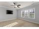 Bright bedroom with neutral walls and a ceiling fan, featuring a large window for natural light at 198 Gentry Dr, Pittsboro, NC 27312