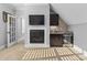 Cozy room with a fireplace, TV, and wet bar featuring stainless steel mini fridge and dark wood cabinetry at 198 Gentry Dr, Pittsboro, NC 27312