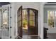 Elegant front door with glass panes letting in natural light to the hardwood floor entryway at 198 Gentry Dr, Pittsboro, NC 27312