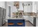 Bright kitchen features an island with blue cabinetry, granite countertops, and stainless steel appliances at 198 Gentry Dr, Pittsboro, NC 27312