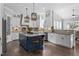 Bright kitchen featuring a center island with bar seating, white cabinetry, and stainless steel appliances at 198 Gentry Dr, Pittsboro, NC 27312