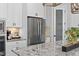 Open kitchen area with a stainless steel refrigerator, granite countertops, and a pantry at 198 Gentry Dr, Pittsboro, NC 27312