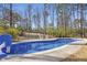 Backyard pool with basketball hoop and white lounge chairs, surrounded by tall trees at 198 Gentry Dr, Pittsboro, NC 27312