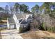 Rear view of the two-story home with a two-car garage, showcasing its backyard and natural surroundings at 198 Gentry Dr, Pittsboro, NC 27312