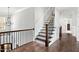 Elegant staircase with dark wood steps, black iron railing, and white trim, leading to the upper level at 198 Gentry Dr, Pittsboro, NC 27312