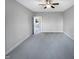 This bedroom features grey walls and carpet, a ceiling fan, and a window view to the trees outside at 201 Silver Creek Dr, Clayton, NC 27520
