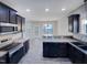 This is a kitchen with dark cabinets and hard surface countertops with open view to another room at 201 Silver Creek Dr, Clayton, NC 27520
