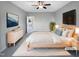 This staged bedroom features a ceiling fan, television, light wood furniture, and a light-colored rug at 201 Silver Creek Dr, Clayton, NC 27520