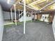 Unfinished basement with painted foundation walls, exposed ceiling and added turf at 2024 Fox Den, Clayton, NC 27527