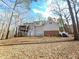 Back of house with a combination of neutral siding and brick accents, plus a screened porch, set in a wooded area at 2024 Fox Den, Clayton, NC 27527