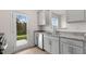 Kitchen featuring stainless steel appliances, gray cabinetry, granite countertops, and backyard access at 208 Starlight St, Sanford, NC 27330